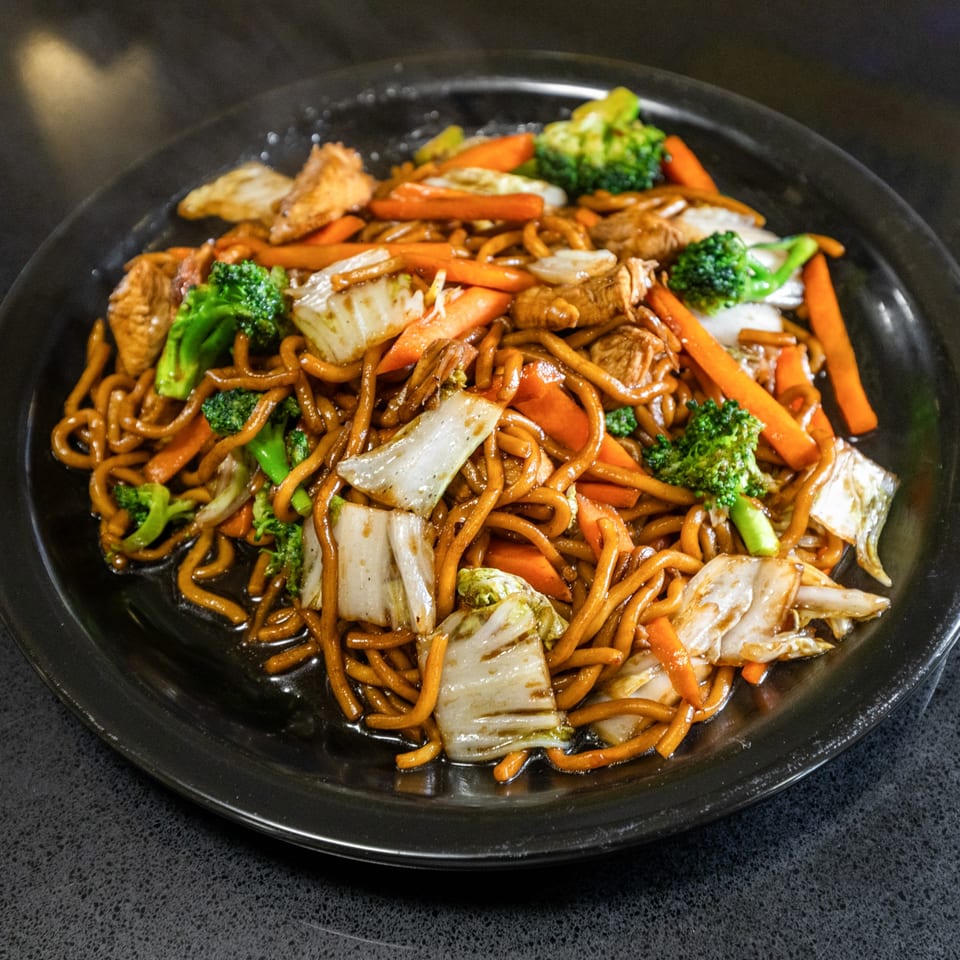 Thai Esane's Pad See Ew with thick noodles, chicken, broccoli, carrots, and cabbage.